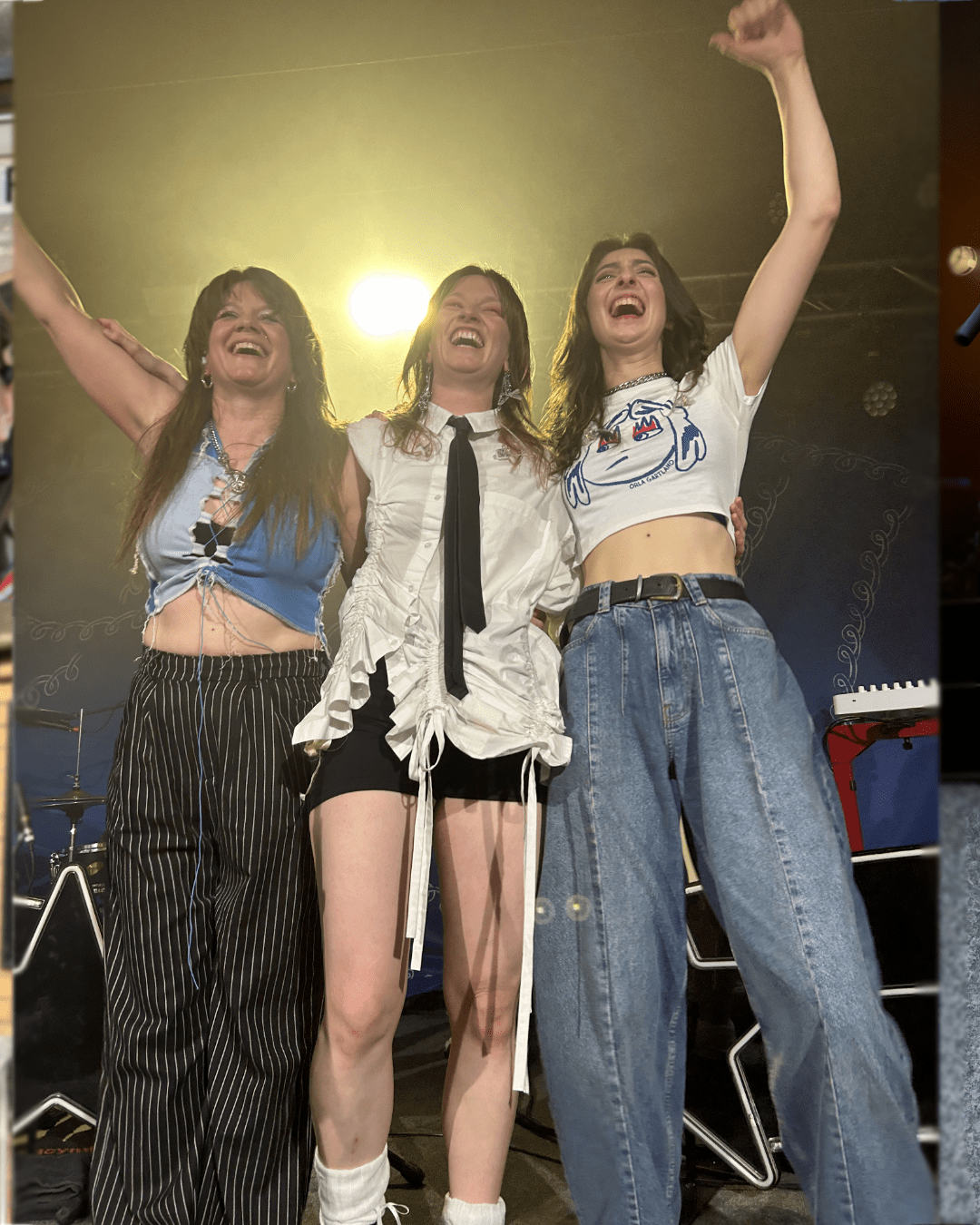 Picture of Sarah, Orla and Scarlet on stage waving