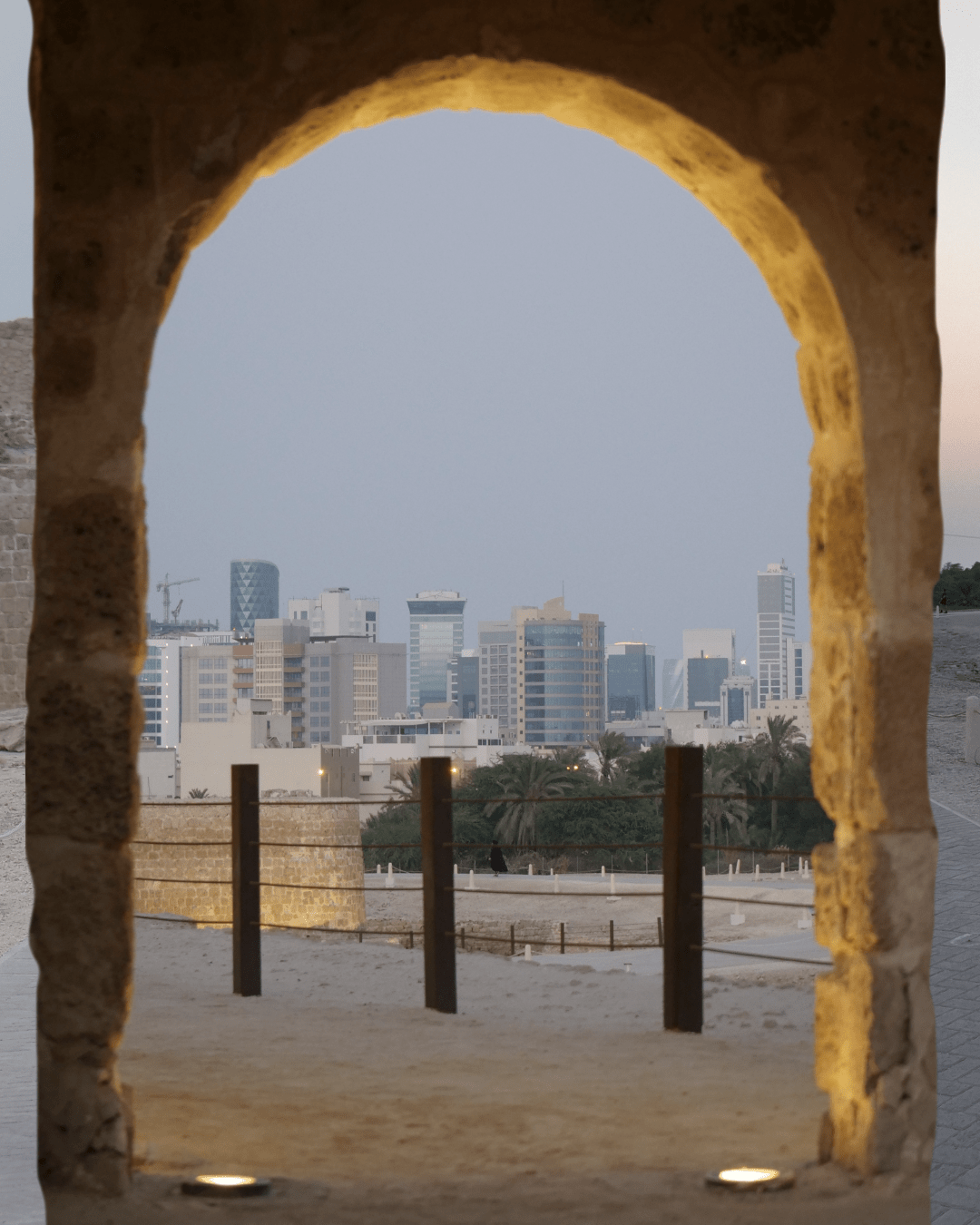 Picture of the skyline in the distance though one of the arches. The contrast of a building from the 11th century with some 21st century skyscrapers in the background