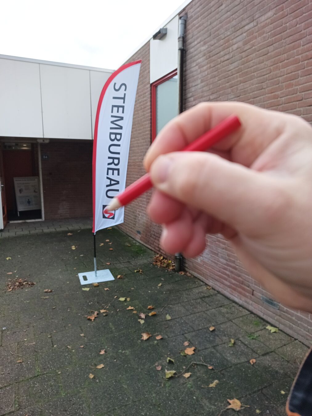stembureau vlag waar het lijkt dat het rode bolletje wordt ingekleurd door mijn potlood in mijn hand op de voorgrond