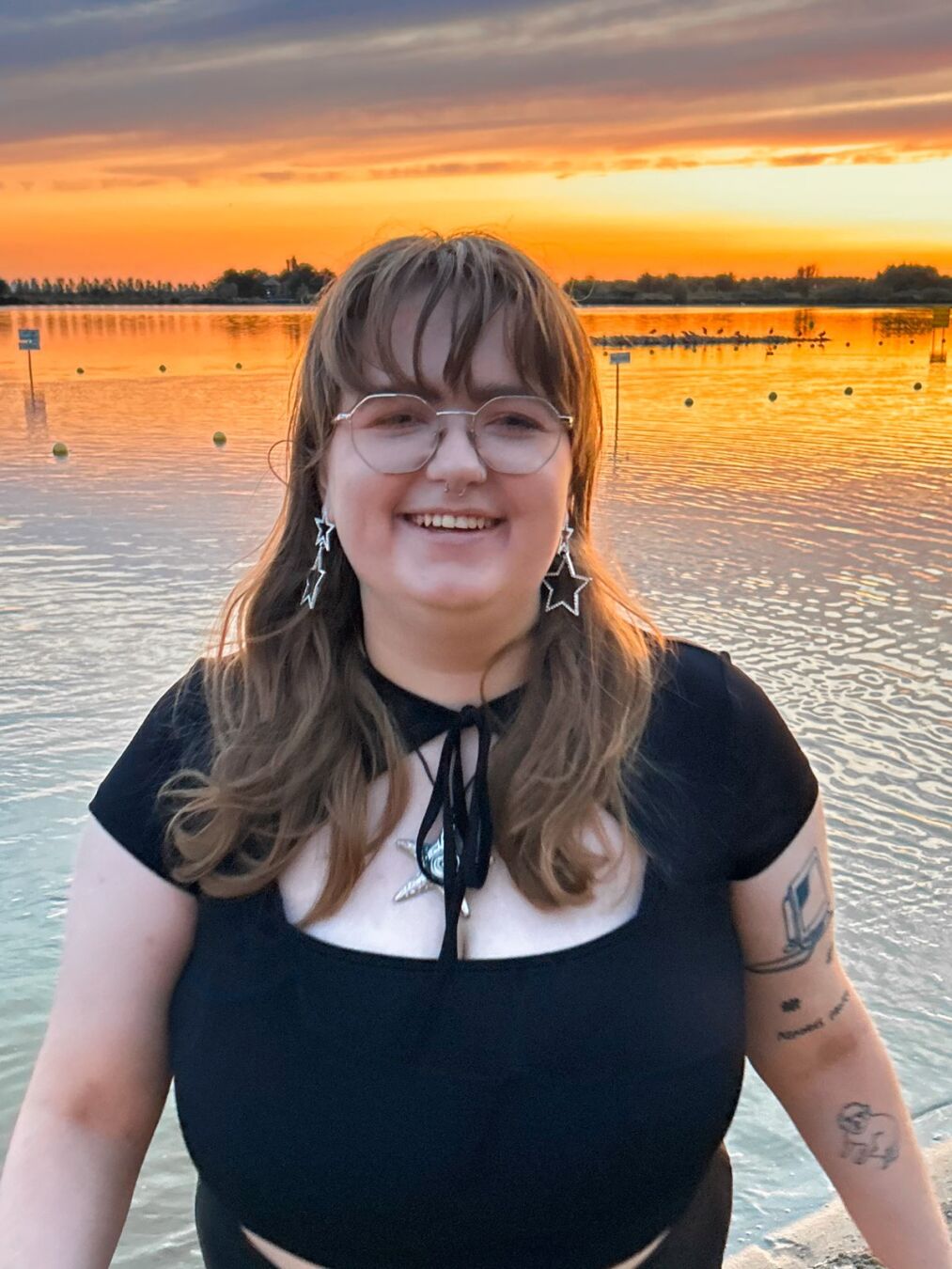 Emily at the beach with a sunset behind her